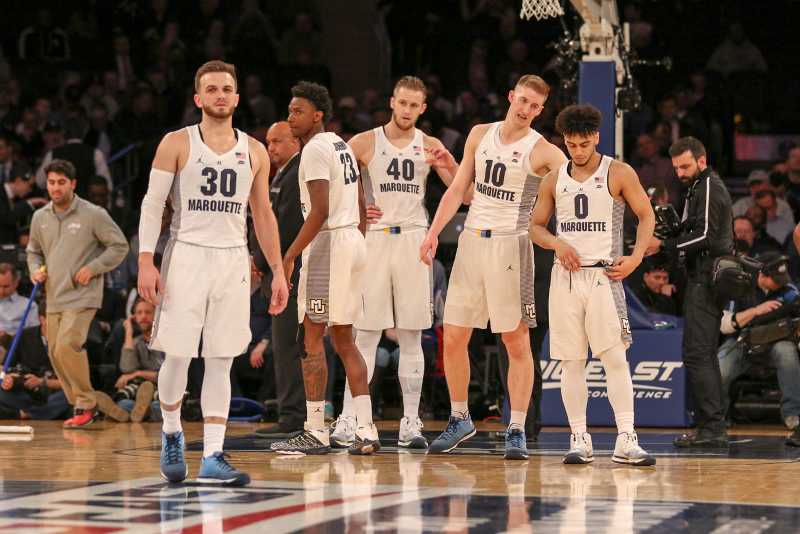 Men's basketball players converse on the court at Madison Square Garden during the BIG EAST Tournament.
